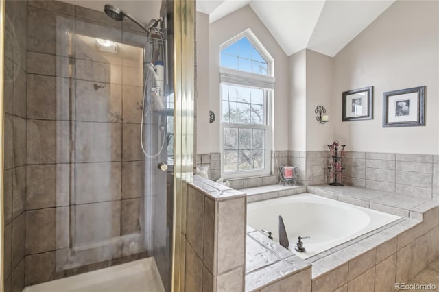 full bath with a shower stall, vaulted ceiling, and a garden tub