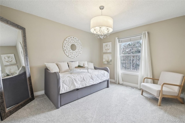 bedroom featuring an inviting chandelier, carpet, baseboards, and a textured ceiling