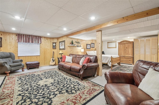 carpeted living area with wood walls and recessed lighting