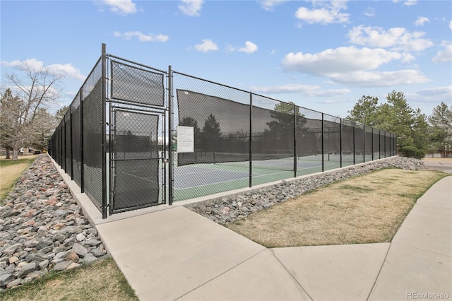 view of tennis court featuring a gate and fence