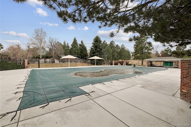 pool featuring fence and a patio area