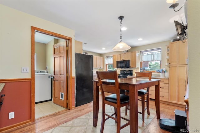 dining space featuring washer / clothes dryer and light wood-type flooring