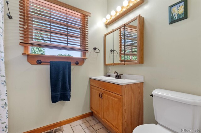 bathroom featuring a wealth of natural light, vanity, and toilet