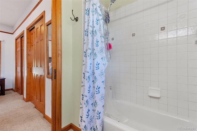 bathroom with baseboards and shower / bath combination with curtain