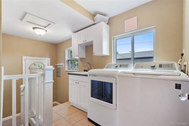 clothes washing area featuring plenty of natural light, a sink, washer and clothes dryer, and light tile patterned floors