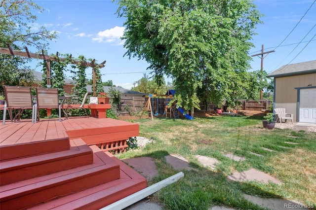 view of yard with a playground, a fenced backyard, and a wooden deck