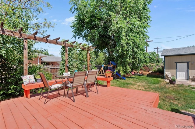 wooden terrace featuring a storage unit, a lawn, and a playground