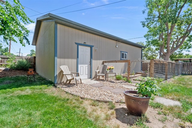 rear view of property featuring a yard and fence