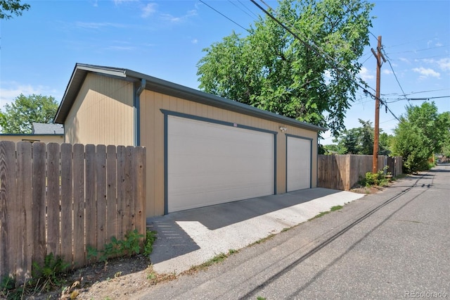 detached garage featuring fence