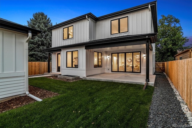 rear view of house with a patio area, a fenced backyard, and a lawn