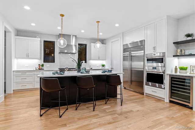 kitchen with tasteful backsplash, open shelves, wall chimney exhaust hood, appliances with stainless steel finishes, and wine cooler