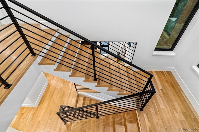 stairs featuring wood finished floors and baseboards