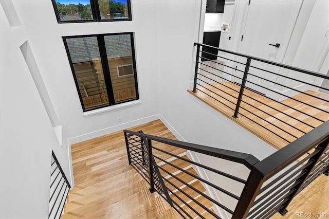 staircase featuring baseboards and wood finished floors