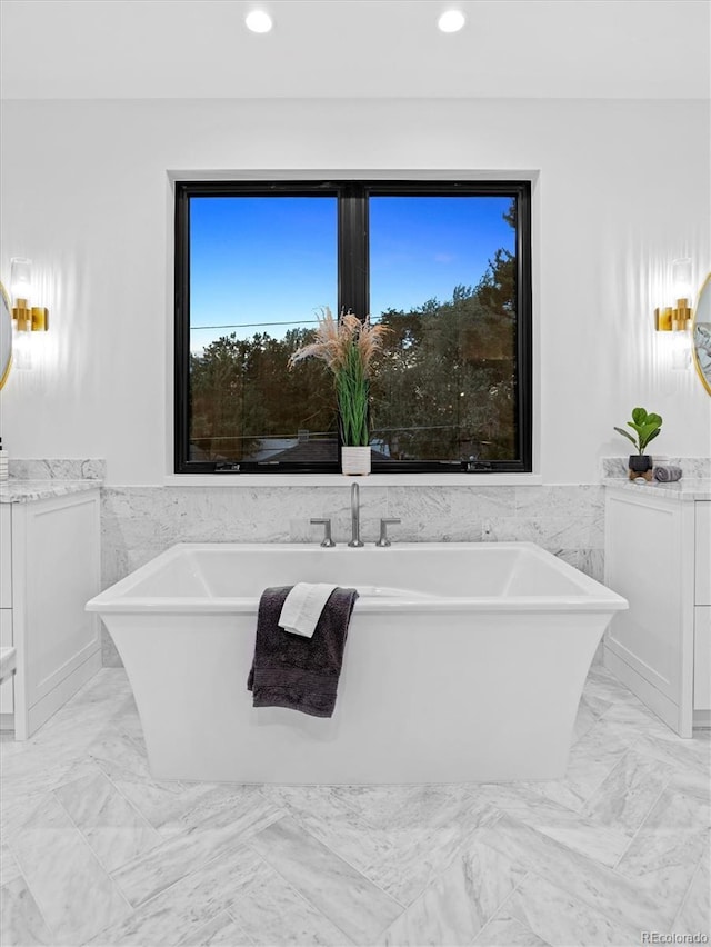 full bath featuring recessed lighting, wainscoting, and marble finish floor