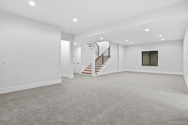 finished below grade area with carpet flooring, baseboards, recessed lighting, and stairs