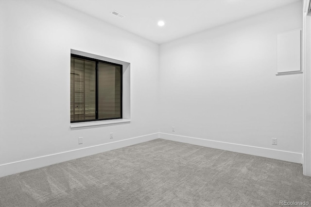 carpeted spare room featuring visible vents, baseboards, and recessed lighting