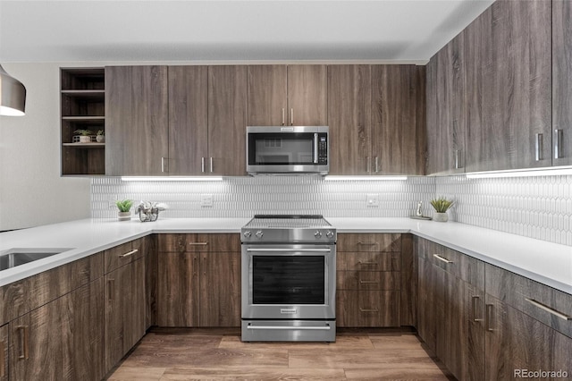 kitchen featuring backsplash, light countertops, open shelves, and stainless steel appliances
