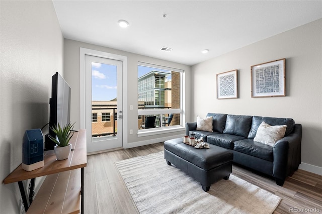 living area featuring recessed lighting, light wood finished floors, visible vents, and baseboards