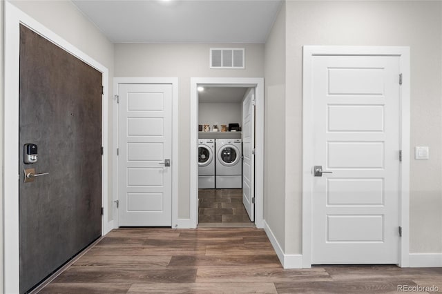 laundry room featuring independent washer and dryer, wood finished floors, baseboards, and visible vents