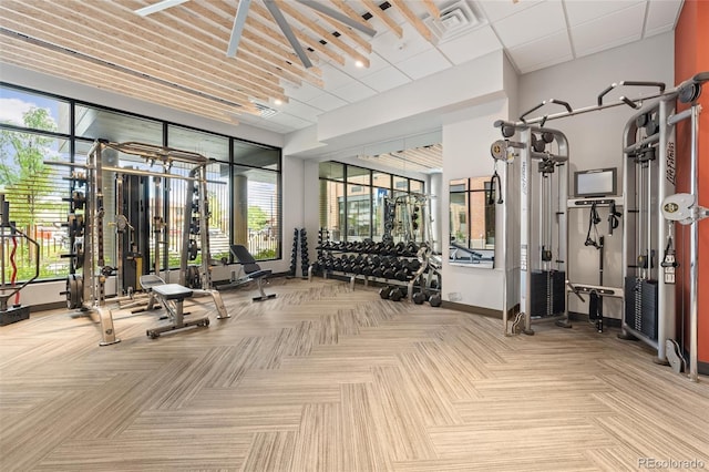 exercise room featuring baseboards, visible vents, and a wealth of natural light