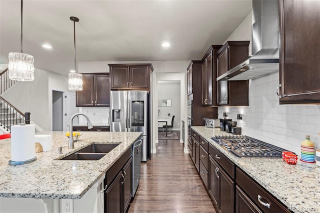 kitchen with a sink, dark brown cabinetry, dark wood-style floors, and wall chimney range hood