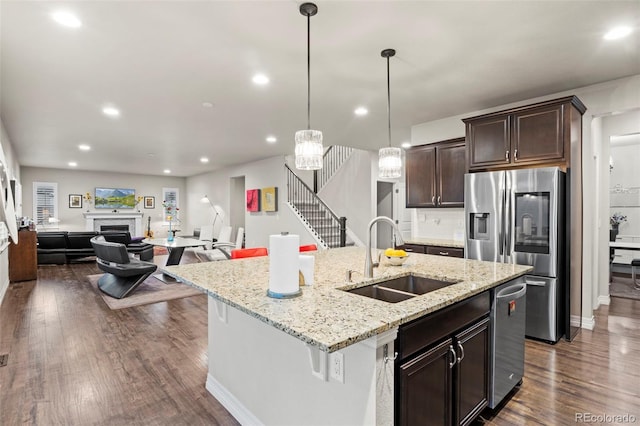 kitchen featuring a sink, dark wood-style floors, appliances with stainless steel finishes, a fireplace, and dark brown cabinets