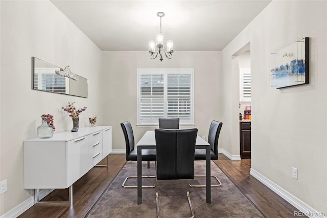 dining space with a chandelier, baseboards, and dark wood-style flooring