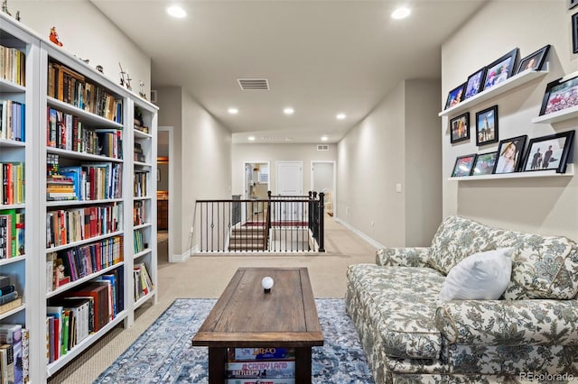 living area featuring recessed lighting, carpet flooring, an upstairs landing, and visible vents