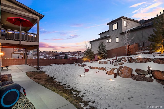 yard covered in snow featuring a patio area and fence