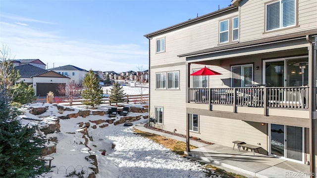 snow covered property with a patio and a residential view