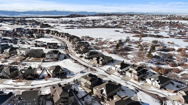 snowy aerial view with a residential view and a mountain view