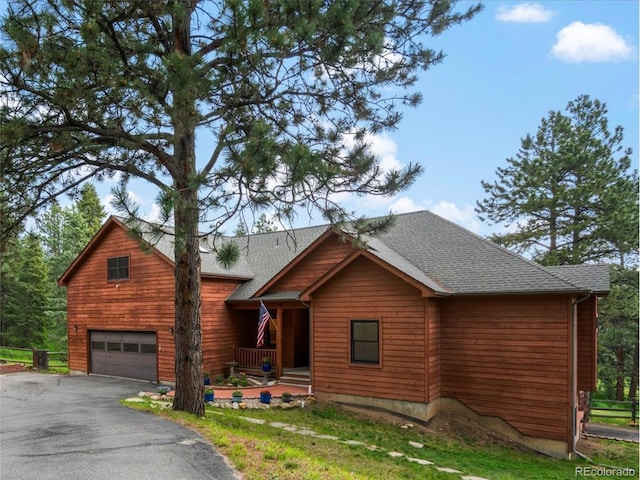28465 Cragmont Dr, Evergreen, CO 80439 - chalet / cabin featuring a porch, an attached garage, asphalt driveway, and roof with shingles