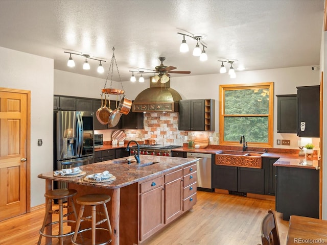 28465 Cragmont Dr, Evergreen, CO 80439 - kitchen featuring stainless steel appliances, a ceiling fan, dark stone counters, light wood finished floors, and backsplash