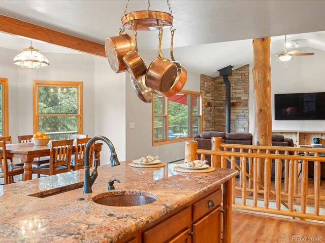 28465 Cragmont Dr, Evergreen, CO 80439 - kitchen featuring a wood stove, light wood-style floors, a ceiling fan, plenty of natural light, and vaulted ceiling