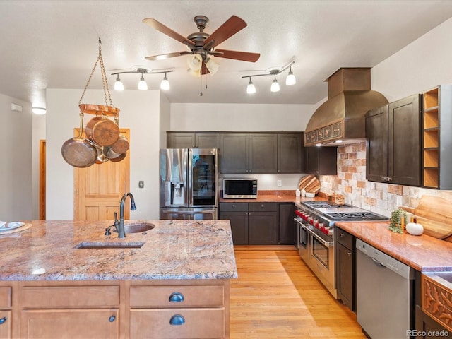 28465 Cragmont Dr, Evergreen, CO 80439 - kitchen featuring appliances with stainless steel finishes, premium range hood, a ceiling fan, light stone countertops, and backsplash