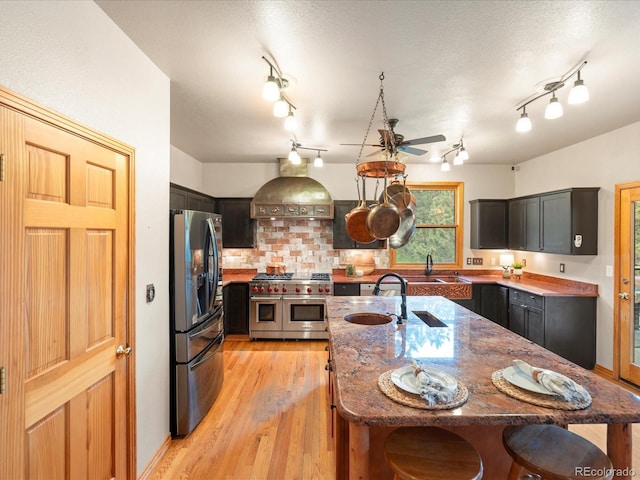 28465 Cragmont Dr, Evergreen, CO 80439 - kitchen featuring stainless steel appliances, a kitchen bar, ceiling fan, stone countertops, and light wood-type flooring