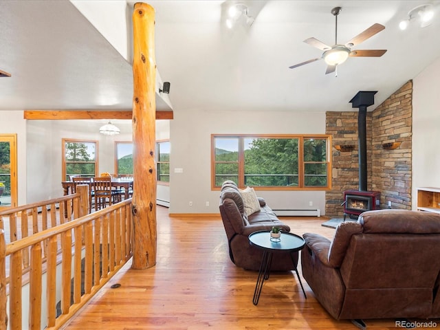 28465 Cragmont Dr, Evergreen, CO 80439 - living area with a wood stove, baseboard heating, wood finished floors, ceiling fan, and lofted ceiling