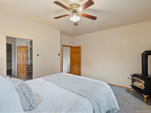 28465 Cragmont Dr, Evergreen, CO 80439 - carpeted bedroom featuring a wood stove and ceiling fan