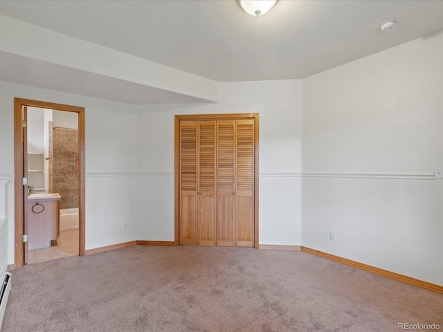 28465 Cragmont Dr, Evergreen, CO 80439 - unfurnished bedroom with a closet, carpet, a baseboard heating unit, and connected bathroom