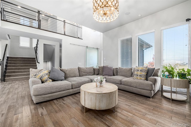 living room with a barn door, a healthy amount of sunlight, and wood-type flooring