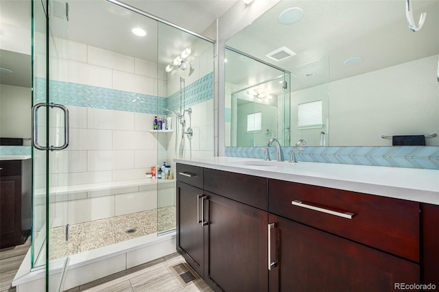 bathroom featuring vanity and a shower with shower door