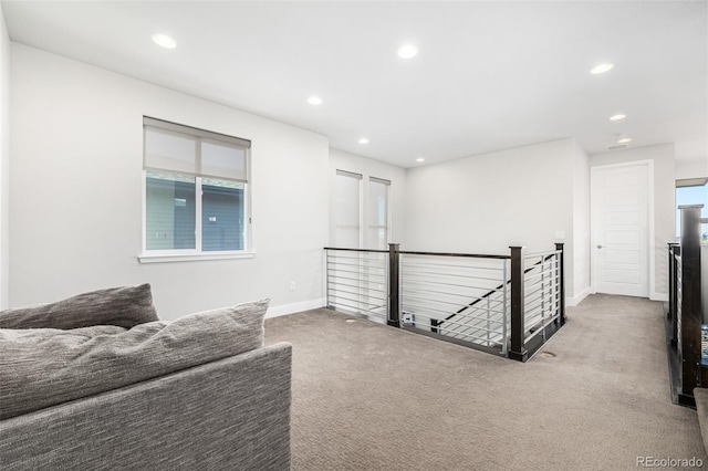 hall with a wealth of natural light and carpet floors