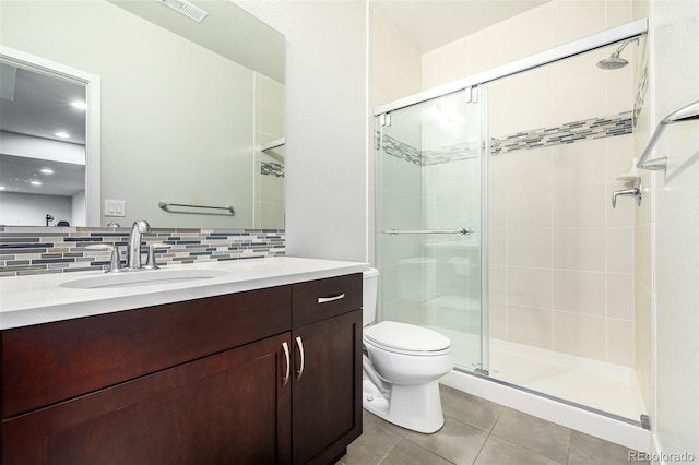 bathroom with toilet, a shower with door, tile patterned flooring, vanity, and backsplash