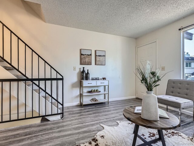 17681 E Loyola Dr Unit E, Aurora, CO 80013 - sitting room with wood finished floors, a textured ceiling, and stairs