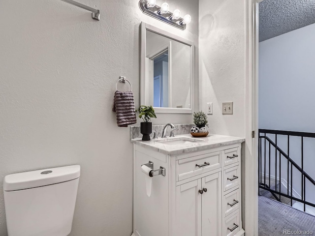 17681 E Loyola Dr Unit E, Aurora, CO 80013 - half bathroom featuring vanity and a textured wall