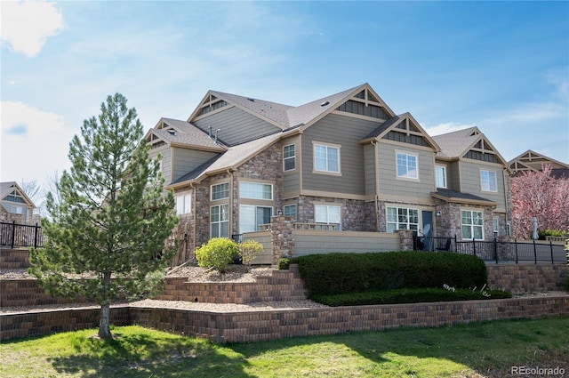 craftsman house with fence, board and batten siding, and stone siding