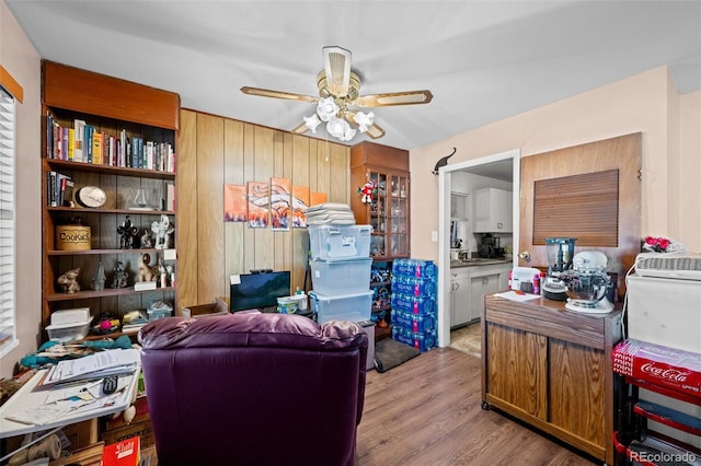 office with ceiling fan, wood walls, and light wood-type flooring