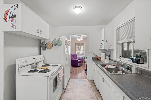 kitchen featuring electric stove, white cabinets, sink, and a wealth of natural light