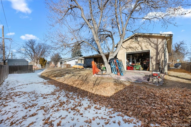 snow covered house featuring a garage