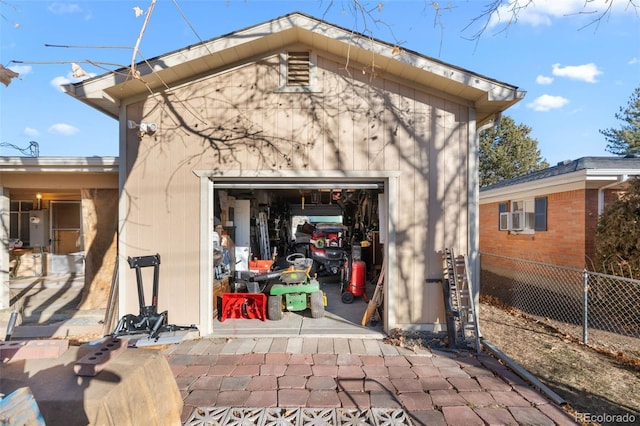 rear view of house featuring a garage and an outbuilding